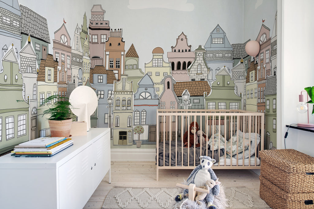 London Houses, Mural Wallpaper in summer featured on a wall of a kid’s room with toys, wooden floor and a wooden crib