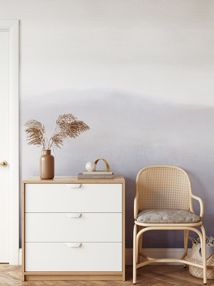 Marigold Mountain Watercolor Wallpaper in a hallway with a side console and rattan chair.