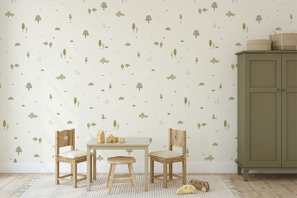 A cozy children’s room with soft lighting, featuring Mini Timberland pattern wallpaper in Green with subtle tree and animal designs. The room includes a small wooden table set, a green cabinet, and playful toys scattered on a woven rug, creating a warm and inviting play space.