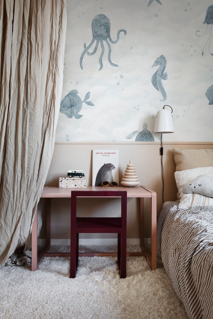 Ocean Friends, Pattern Wallpaper in blue featured on a wall of a bedroom with fluffy floor mat and a comfortable bed and patterned bed sheets 