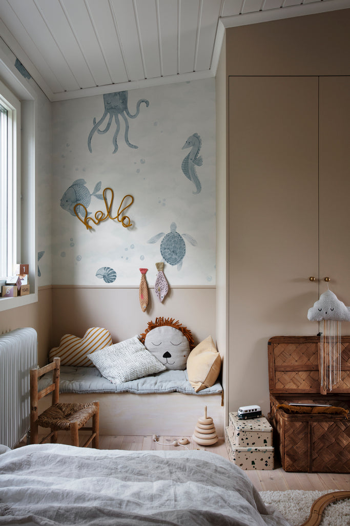 Ocean Friends, Pattern Wallpaper in blue featured on a wall of kid’s playroom with plushies and toys