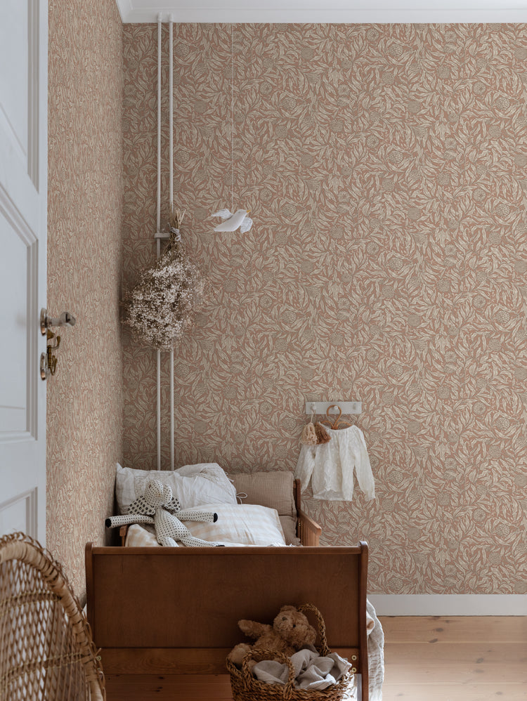 Olof, Floral Pattern Wallpaper in Terracotta featured on the wall of a kid’s bedroom with a bed and rattan chair