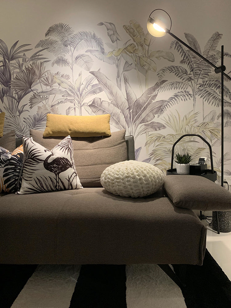 Contemporary room with a Palm Garden, Tropical Mural Wallpaper,  featuring a sleek chaise lounge on a striped rug, a modern lamp on a side table.