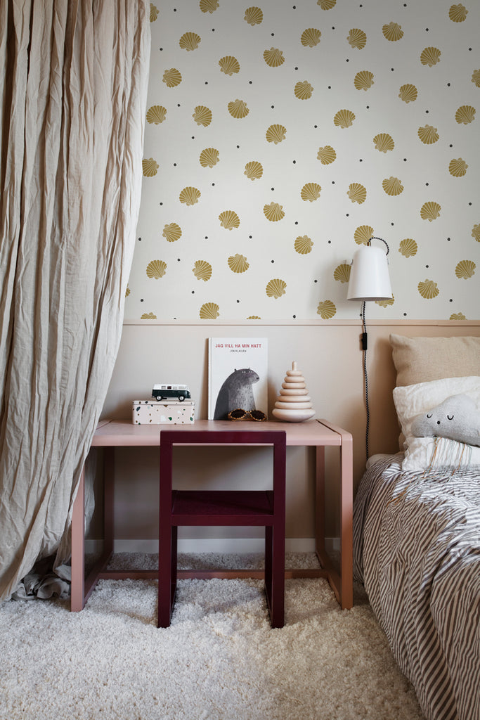 Picking Seashells, Wallpaper in Sand Featured on a wall of a kid’s room with a bed on the side and a wooden study table with several toys on top. 