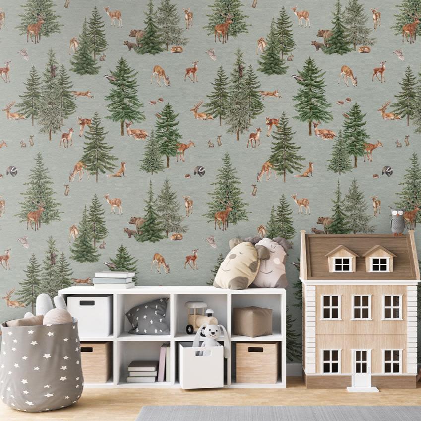 Pine forest, Pattern Wallpaper in blue colourway, the children's room includes a white storage unit with cubbies containing toys, books, and storage bins. On top of the storage unit, there are plush toys, a small wooden house, and a decorative owl. A string of star-shaped decorations hangs down on the right. A grey storage basket with white stars, filled with plush toys, adds to the playful and organized atmosphere.
