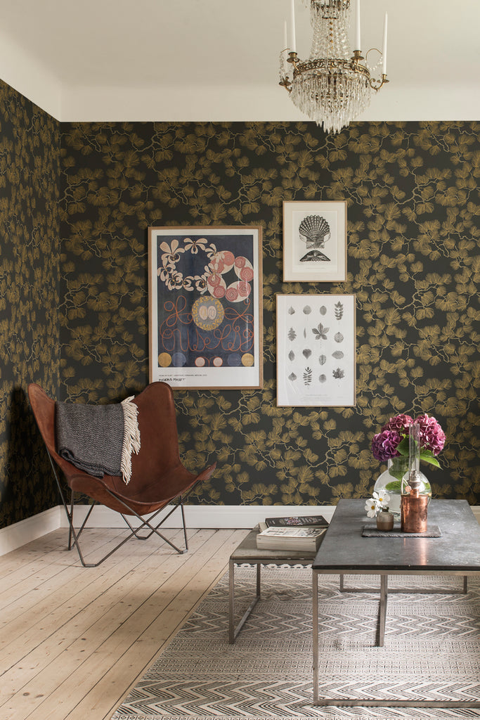 Linnea, Floral Pattern Wallpaper in dark blue featured on a wall of a bedroom with a bed with brown sheets and pillows