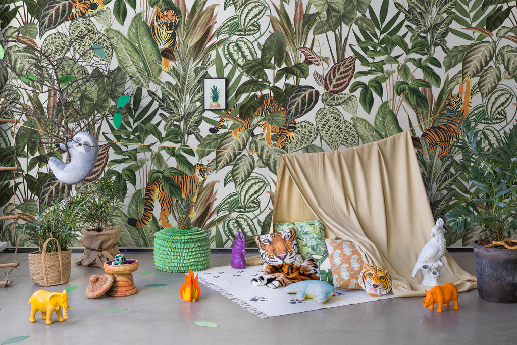 Playful Tiger, Pattern Wallpaper in sand colourway featured in a kid’s playroom with scattered toys and a pale yellow fabric acting as a tent