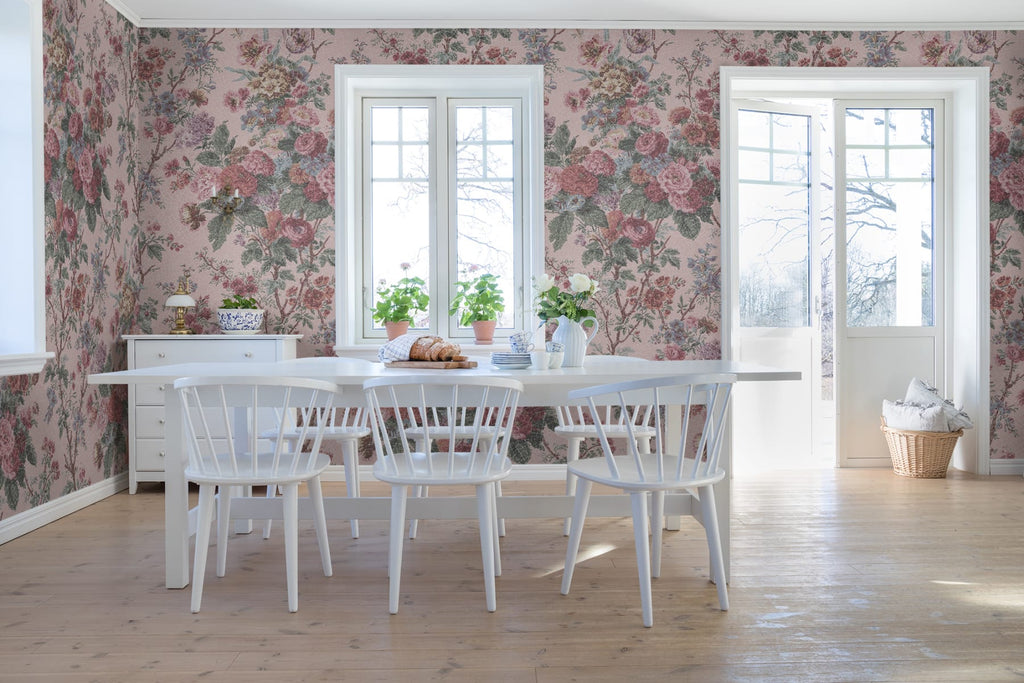 Porcelain, Floral Pattern Wallpaper in blush pink featured on a wall of a naturally lit dining area with white dining table and chairs