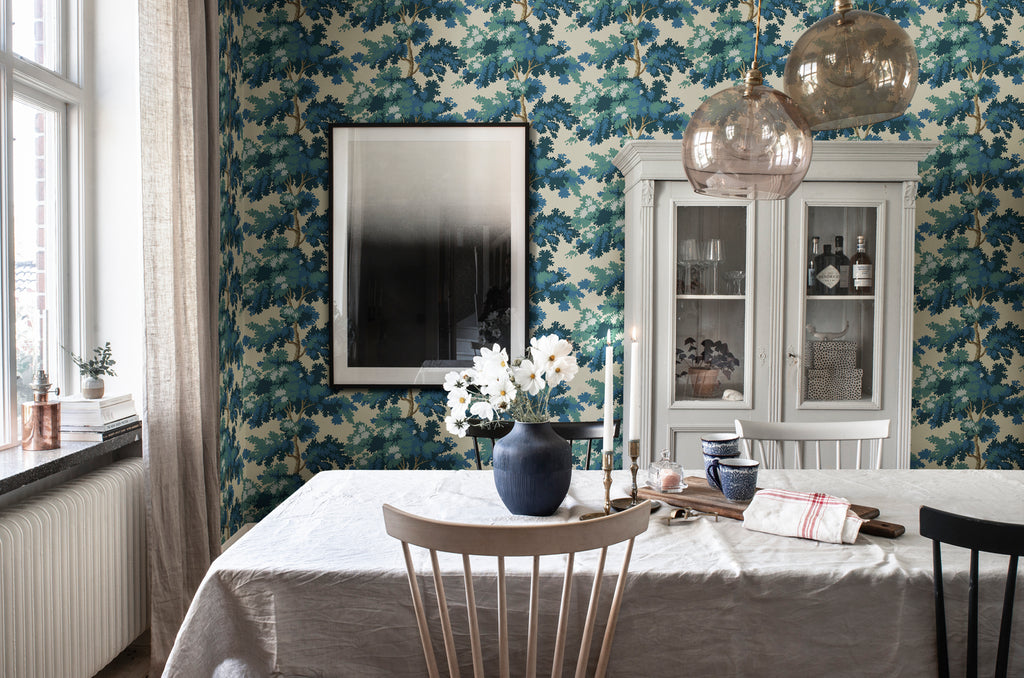 Raphael Floral, Wallpaper in Dark Blue featured on a wall of a dining area with dirty white table cloth and a black vase with flower
