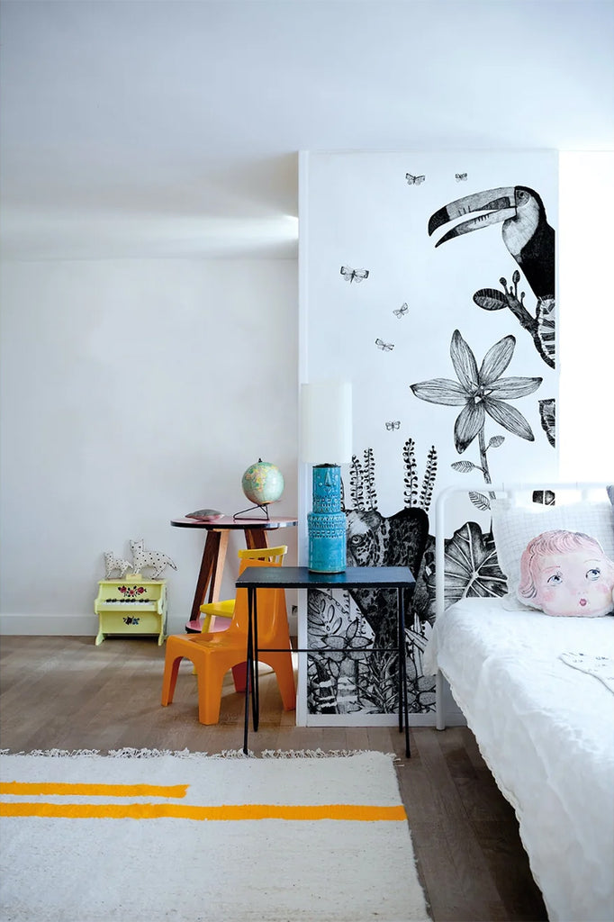 A room adorned with Safari Wild, Animal Mural Wallpaper, showcasing a variety of animals and plants in an artistic sketch style, harmonizing with the modern furniture and decor.