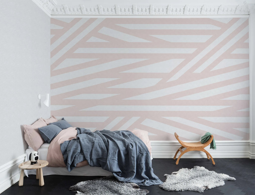 Sailor's Sea, Striped Wallpaper in Blush Pink as seen on the wall of a bedroom with grey floor mats and bed with dark blue bed sheets and pink pillows that matches its aesthetics