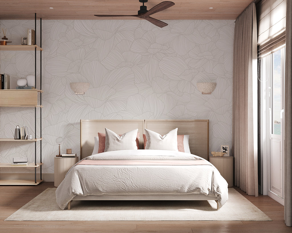 Serene bedroom with Saltwater Blooms, Pattern Wallpaper in Sand. Features include a cozy double bed, wooden side tables, wall-mounted lamps, a ceiling fan, and a window with sheer curtains. The room exudes a warm, inviting atmosphere.