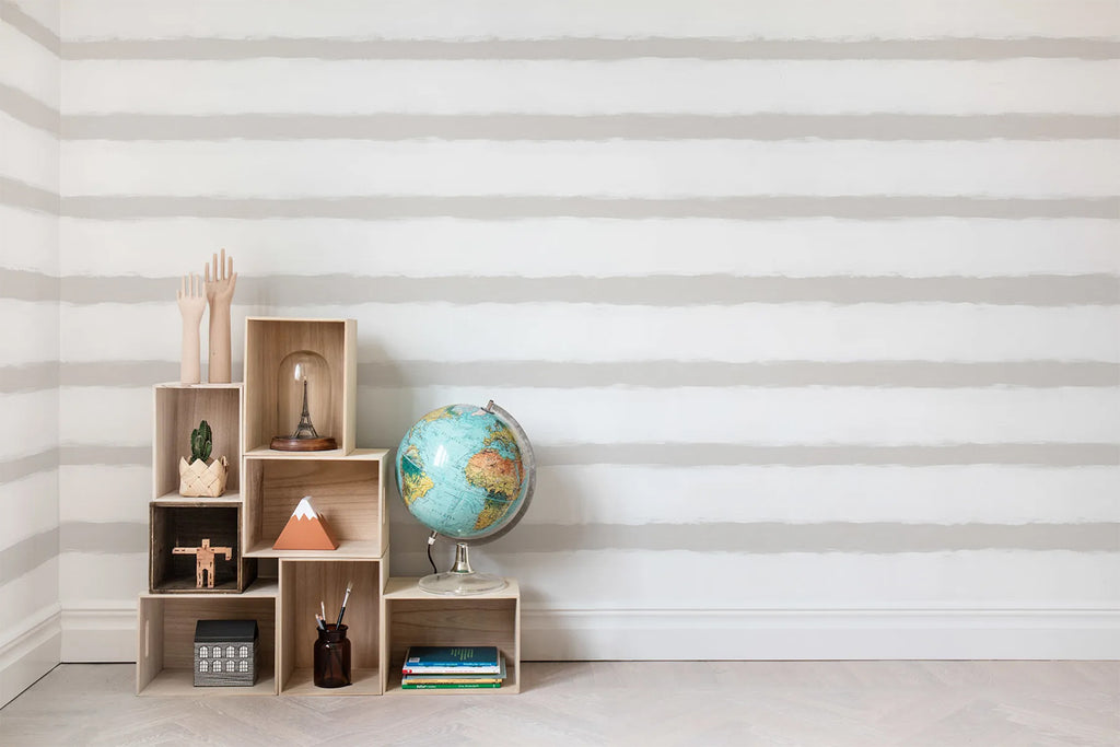 Sand Lines, Striped Wallpaper as seen on a wall of a children’s playroom with storage made for kids that has its toys and a globe