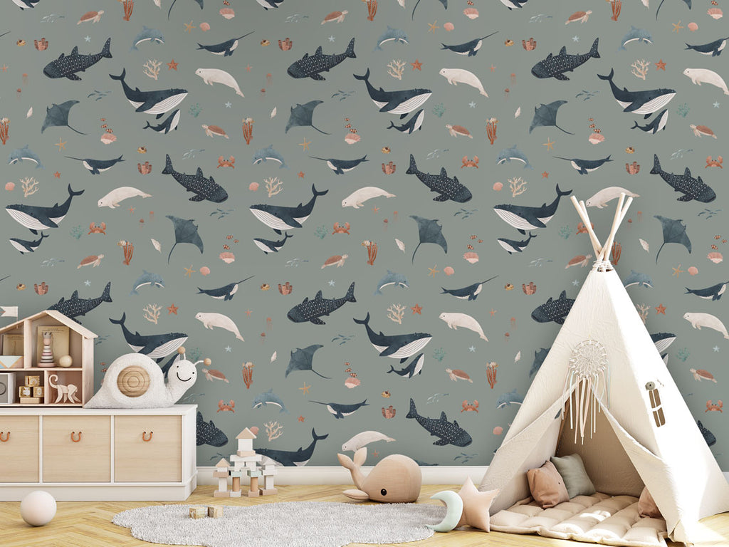 A play area with green Splendid Sea wallpaper, a teepee tent, wooden toys, and soft pastel-colored cushions.