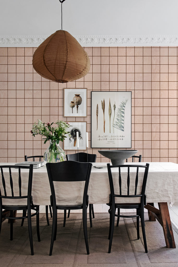 Squares and Tiles illustrations, Wallpaper in Nude featured on a wall of a dining area with a table with white table cloth, and black chairs