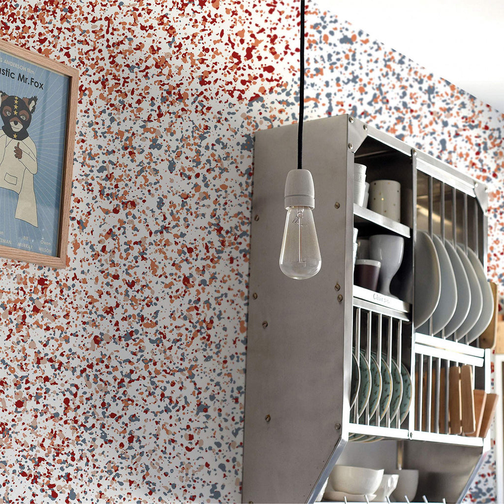 A vibrant interior highlighted by the Stardust, Pattern Wallpaper. The colorful speckles on the wallpaper add a lively atmosphere to the space, complemented by modern lighting and art.