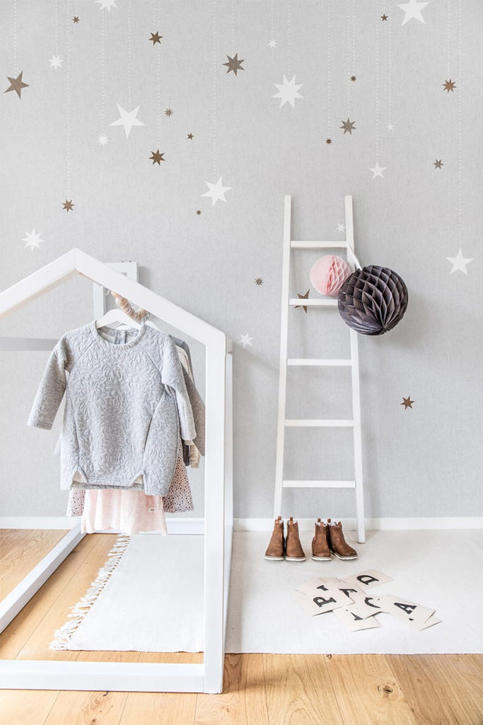 Stargazing, Pattern Wallpaper in light grey featured on a wall of a kid's room with a house frame for clothes and a white ladder