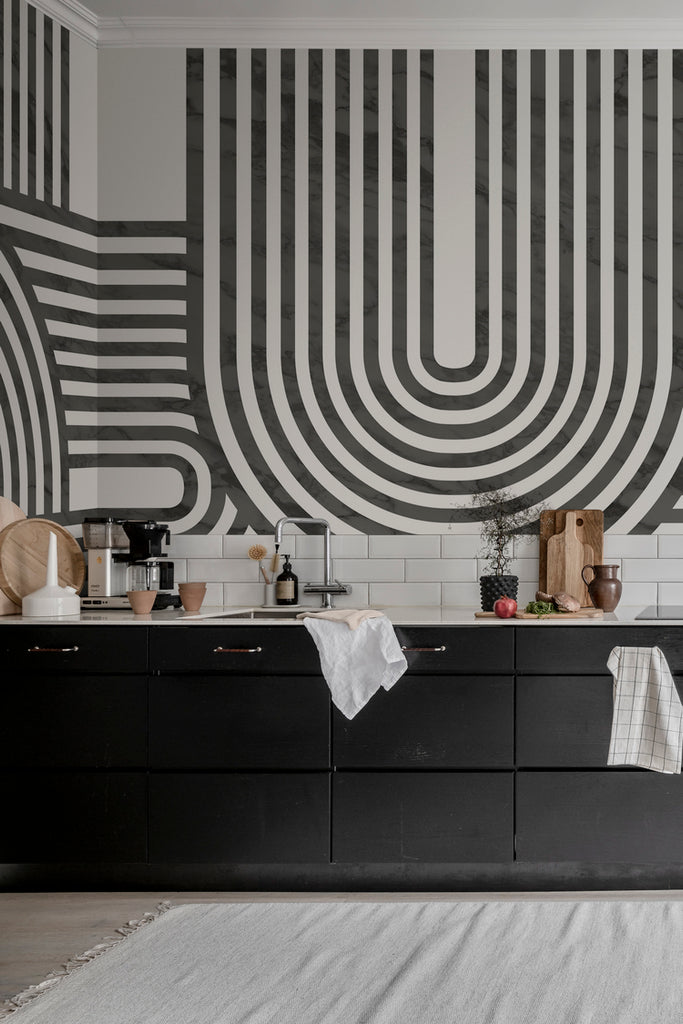 Closed up Stella Arch, Geometric Mural Wallpaper in black featured on the wall of a kitchen area with black cabinets