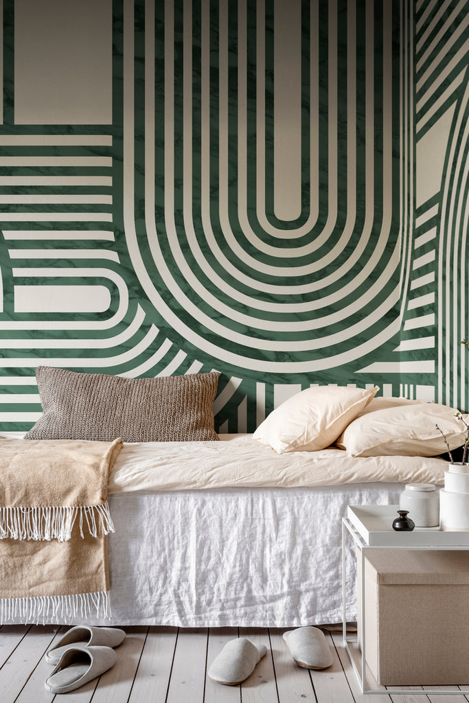 Closed up Stella Arch, Geometric Mural Wallpaper in green featured on the wall of a bedroom with cream and brown bedsheet