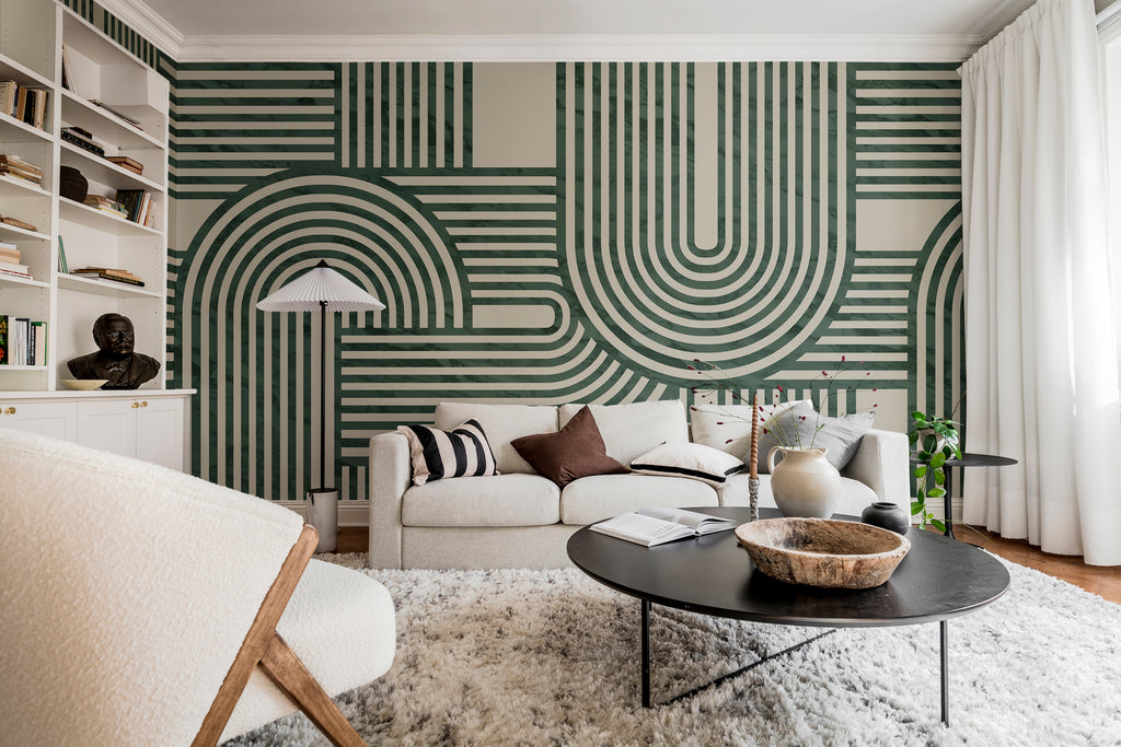 Stella Arch, Geometric Mural Wallpaper in green featured on the wall of a living area with coffee table and sofa