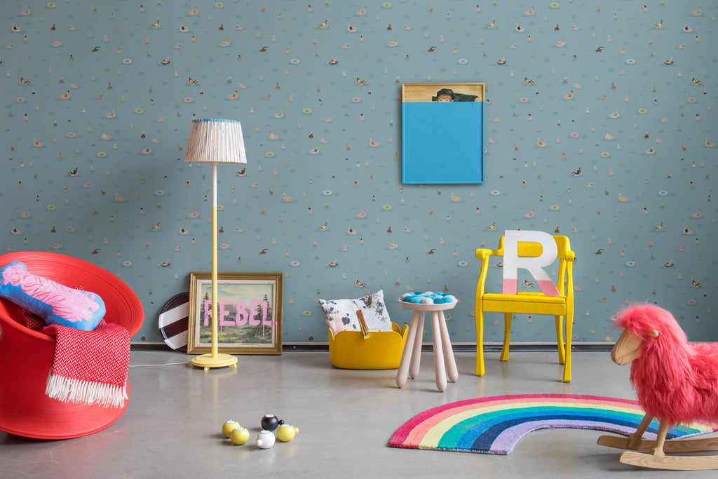 Summer by the Pool, Blue Pattern Wallpaper featured on a wall of a child’s playroom with rainbow floor mat and several toys