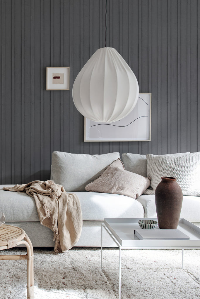 Swiss Cottage, Striped Wallpaper in dark grey, featured on a wall of a living area with soft sofa and pillows