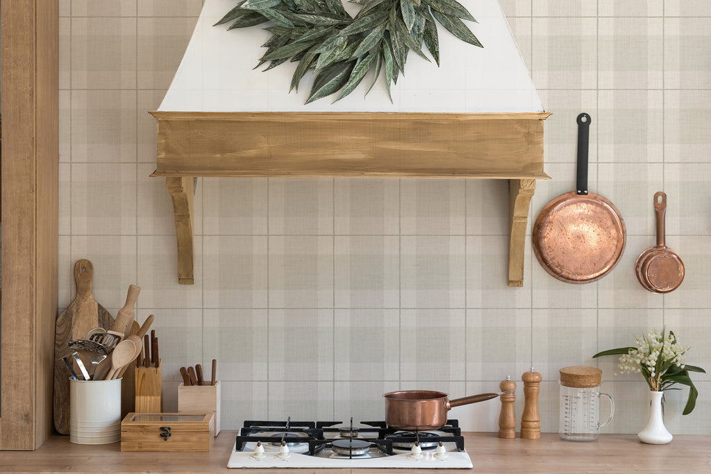 A well-organized kitchen with Tartan Plaid, Pattern Wallpaper . Features include wooden organizers, gas stove, copper cookware, and utensils. A vase of fresh flowers adds a touch of nature.