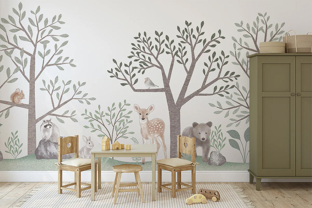 A well-lit children’s room featuring a small wooden table set, striped rug with toys and a green cabinet. The background showcases Walk in the Wild Woods Animal Mural Wallpaper, featuring animals such as squirrels, deer, bear, rabbit interacting in a friendly jungle scene.
