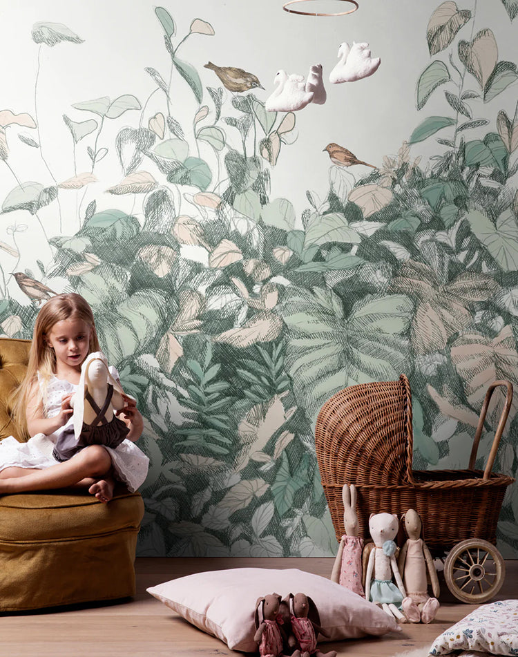 Willow Bush, Wallpaper in forest green, adorns a room’s wall. A girl is seen playing with a stuffed toy, and a rattan stroller, encircled by plush toys, is visible.