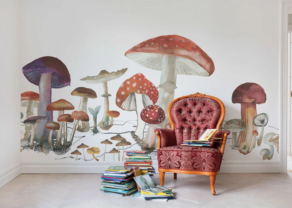 Wonder of Woods, Mushroom Mural Wallpaper as seen on a wall of a room with vintage red sofa chair and stacked books beside it