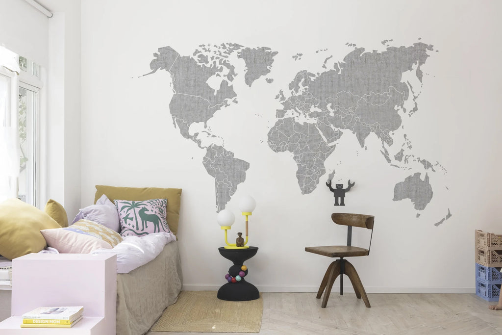 Your Own World Map, Mural Wallpaper in grey featured on a wall of a living area with sofa that has multiple colored pillow, wooden chair and wood floorings