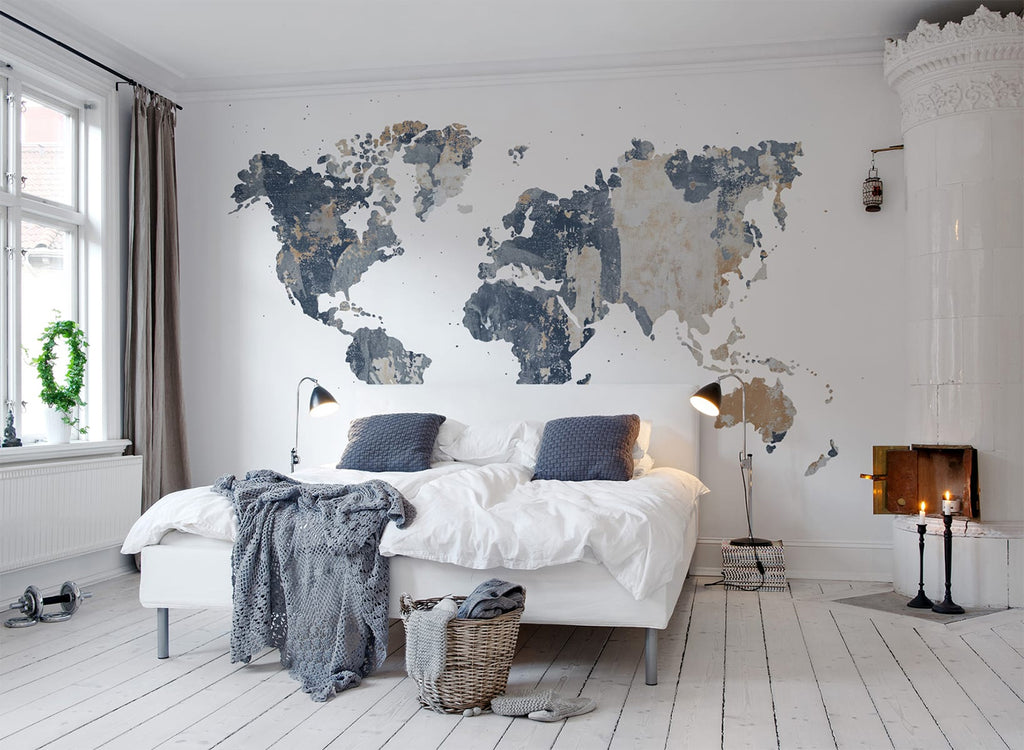 Your Own World Map, Mural Wallpaper in light grey featured on a wall of a bedroom with a bed that has white sheets and grey pillows and throw blanket