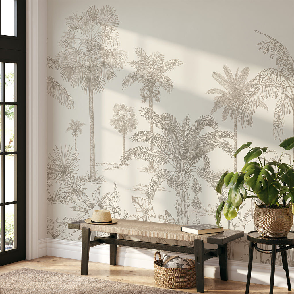 A serene room adorned with the Vintage Palmscape, Tropical Mural Wallpaper in Antique. Detailed palm tree illustrations grace the walls, creating a tranquil ambiance. A sleek wooden bench holds a lamp, books, and vases, seamlessly complementing the tropical theme.