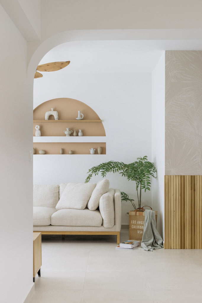 Tropics Botanical, Mural Wallpaper, in light grey, featured on a wall of a living area. 