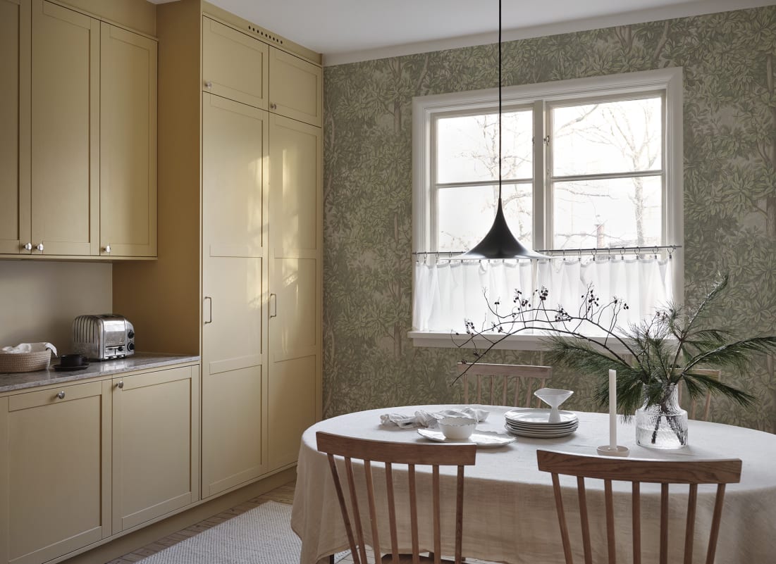 Vintage botanical wallpaper in a dining room with light green botanical pattern