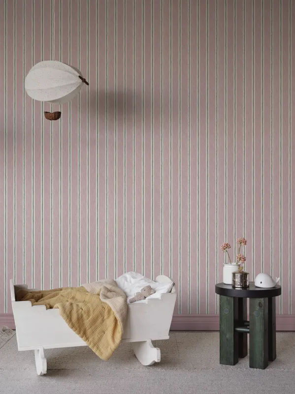 Striped baby girl wallpaper in soft pink nursery setting