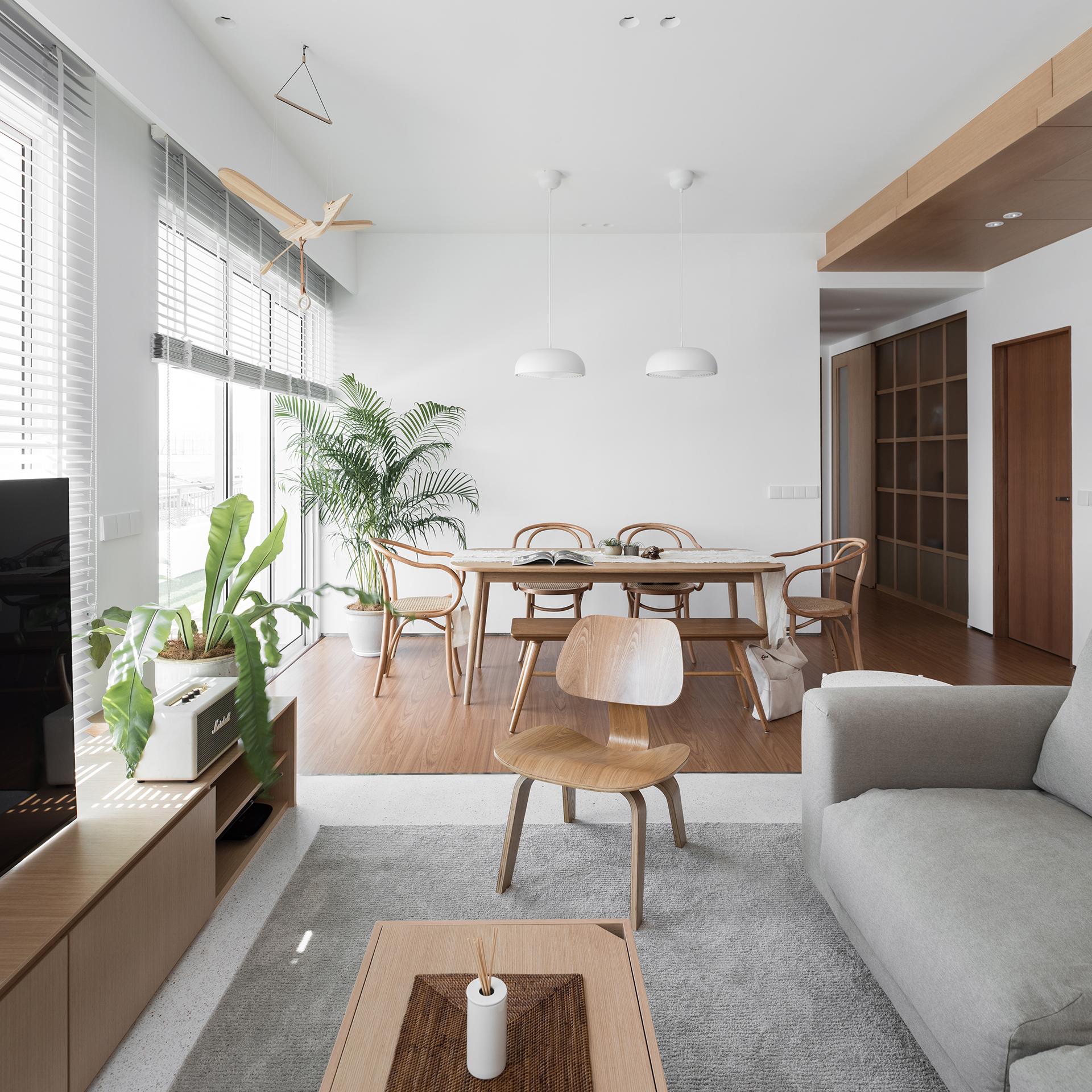 Muji style home decorated in light-coloured wooden furniture, palm leaves, linen sofa