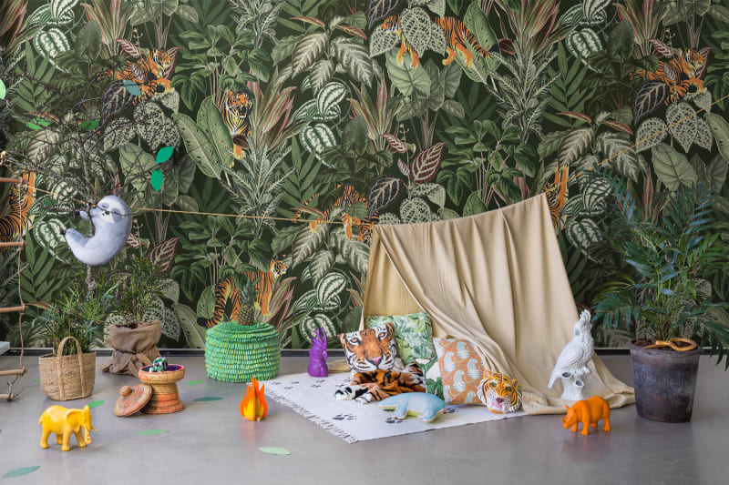Playful Tiger jungle pattern wallpaper with orange tigers among dense tropical leaves behind a play tent and toys in a playroom
